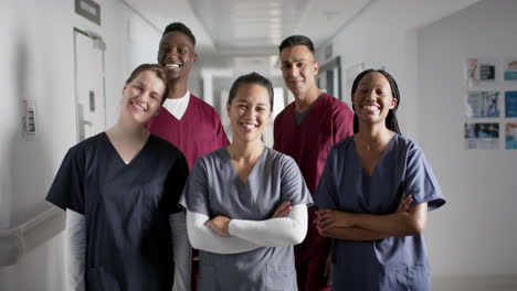 Portrait-of-happy-diverse-male-and-female-doctors-wearing-scrubs-in-hospital,-slow-motion