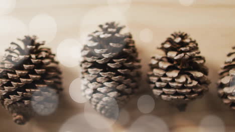 Animation-of-spots-of-light-over-christmas-pine-cones-decorations