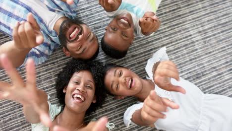 Overhead-Porträt-Glücklicher-Afroamerikanischer-Eltern-Und-Kinder,-Die-In-Der-Sonne-Liegen-Und-Winken,-Zeitlupe