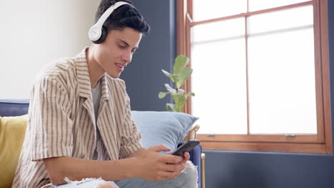 Glücklicher-Biracial-Mann-Mit-Kopfhörern,-Der-Musik-Mit-Smartphone-Hört,-Kopierraum,-Zeitlupe