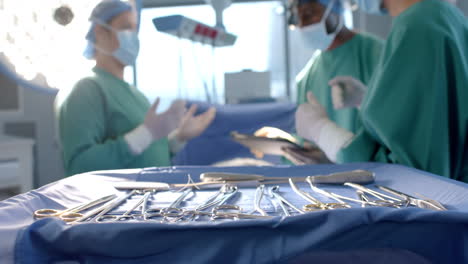 Diverse-female-and-male-surgeons-in-masks-in-discussion-during-operation,-slow-motion