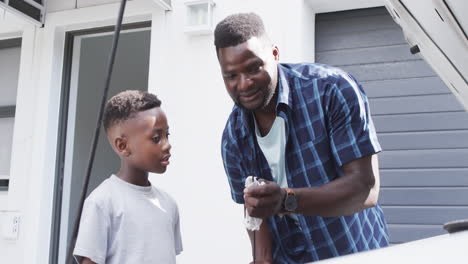 African-American-father-teaches-a-son-car-maintenance-at-home