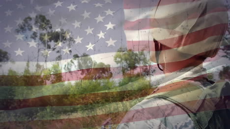 Animation-Der-Amerikanischen-Flagge-über-Einem-Kaukasischen-Männlichen-Soldaten-Mit-Tablet-Auf-Dem-Land