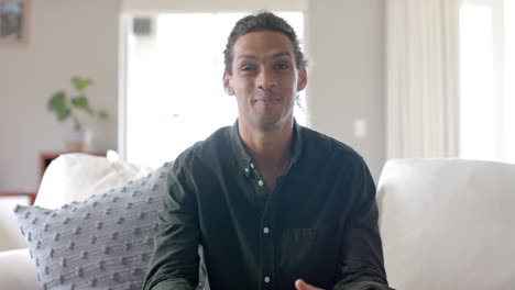 Portrait-of-happy-biracial-man-talking-and-having-video-call-at-home,-slow-motion