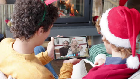 Happy-caucasian-parents-and-sons-having-christmas-tablet-video-call,-slow-motion