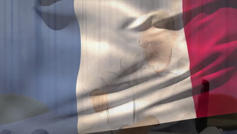 Animation-Der-Flagge-Frankreichs-über-Einem-Glücklichen-Kaukasischen-Männlichen-Architekten,-Der-An-Einem-Bauplan-Arbeitet