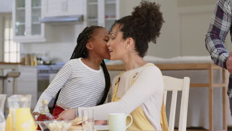 Happy-african-american-parents-and-daughter-having-breakfast-at-table,-slow-motion