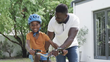 Afroamerikanischer-Vater-Bringt-Sohn-Das-Fahrradfahren-Im-Freien-Bei