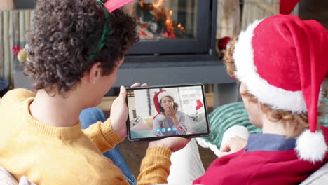 Happy-caucasian-male-and-female-friends-having-christmas-tablet-video-call,-slow-motion
