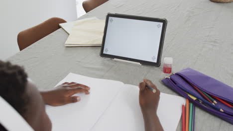 Un-Niño-Afroamericano-Estudia-En-Casa-Usando-Una-Tableta,-Con-Espacio-Para-Copiar