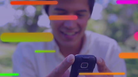 Animation-of-multicolored-bars-over-blurred-close-up-of-smiling-biracial-man-using-smartphone