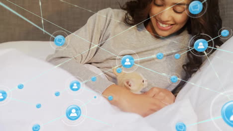 Animation-of-network-of-connected-icons-in-circles-over-happy-biracial-woman-petting-pet-cat