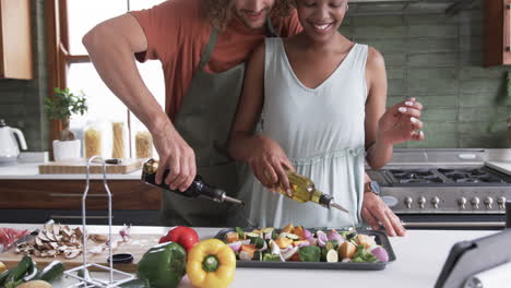 Diverse-couple,-a-young-Caucasian-man-and-an-African-American-woman,-cooking-together-at-home