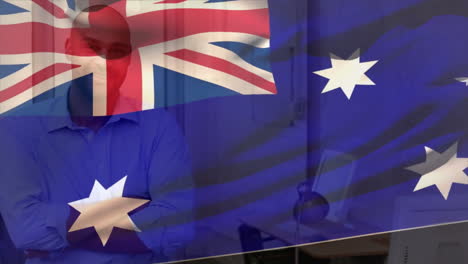 Animation-of-flag-of-australia-over-smiling-biracial-casual-businessman-in-office