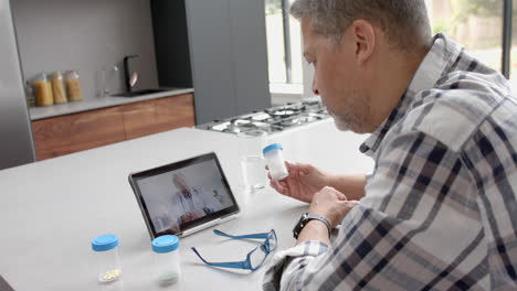 Senior-biracial-male-patient-and-doctor-having-video-call-on-tablet,-slow-motion