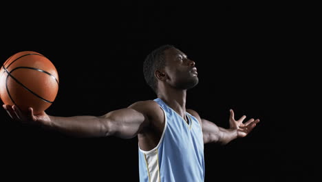 African-American-man-poses-confidently-on-the-basketball-court-on-a-black-background