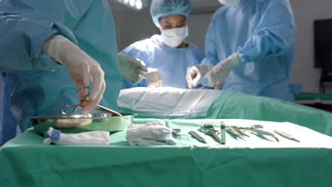 Diverse-surgeons-operating-on-patient-using-surgical-instruments-in-operating-theatre,-slow-motion