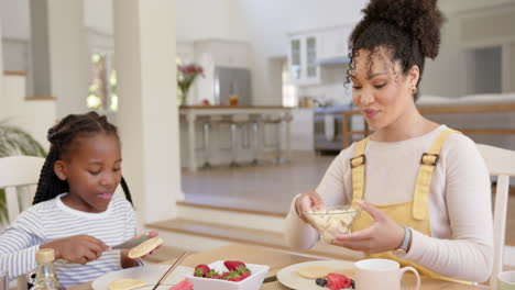 Happy-african-american-parents-and-daughter-having-breakfast-at-home,-slow-motion
