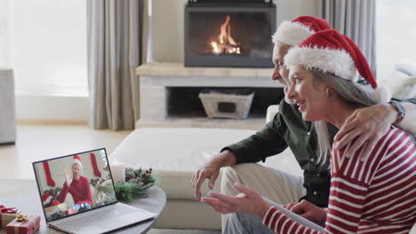 Happy-caucasian-couple-and-male-friend-having-christmas-laptop-video-call,-slow-motion