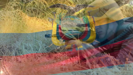Animation-Der-Flagge-Ecuadors-über-Einem-Kaukasischen-Männlichen-Soldaten,-Der-Eine-Waffe-Hält-Und-Sich-Im-Gras-Versteckt