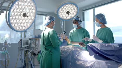 Diverse-female-and-male-surgeons-in-masks-discussing-during-operation,-copy-space,-slow-motion