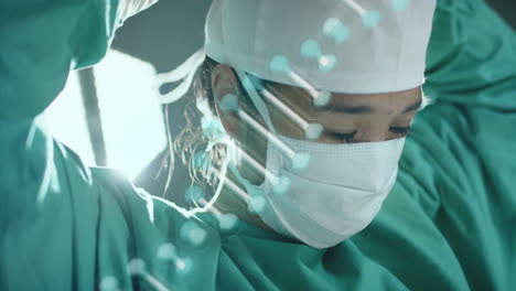 Animation-of-dna-strand-over-asian-female-surgeon-in-hospital