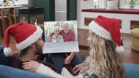 Happy-caucasian-couple-and-senior-parents-having-christmas-laptop-video-call,-slow-motion