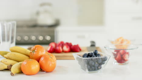 Delicious-colourful-fruits-lying-on-white-counter-in-sunny-kitchen