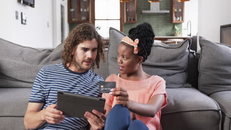 Diverse-couple:-a-young-African-American-woman-and-Caucasian-man-shopping-online-at-home