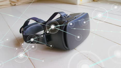 Animation-Eines-Kommunikationsnetzwerks-über-Einem-VR-Headset,-Das-Auf-Einem-Holzboden-Liegt