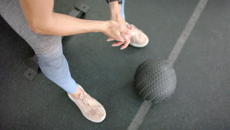 Fit-young-Caucasian-woman-prepares-for-a-workout-at-the-gym-with-a-medicine-ball
