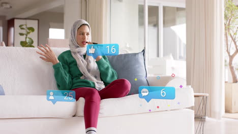 Animation-Von-Verbindungen-Mit-Symbolen-über-Einer-Gemischtrassigen-Frau-Im-Hijab,-Die-Ein-Smartphone-Verwendet