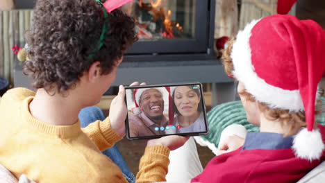 Happy-diverse-couple-and-male-friends-having-christmas-tablet-video-call,-slow-motion