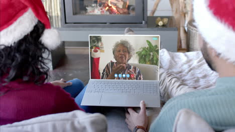 Happy-diverse-couple-and-senior-mother-having-christmas-laptop-video-call,-slow-motion