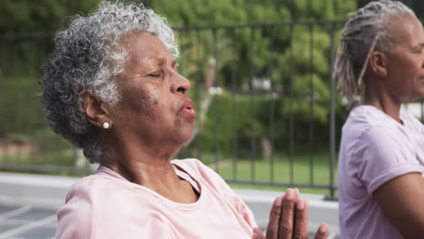 Ältere-Afroamerikanische-Freundinnen-Praktizieren-Yoga-Meditation-Auf-Dem-Balkon-Sitzend,-Zeitlupe