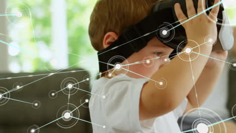 Animation-of-communication-network-over-caucasian-boy-using-vr-headset-at-home