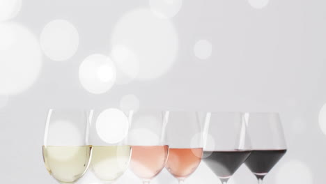 Composite-of-glasses-of-white,-rose-and-red-wine-over-white-background