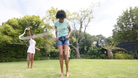 Happy-african-american-mother-skipping-with-husband-daughter-and-son-in-sunny-garden,-slow-motion