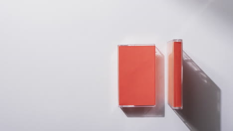 Video-Von-Zwei-Orangefarbenen-Retro-Kassettenboxen-Mit-Kopierplatz-Auf-Grauem-Hintergrund