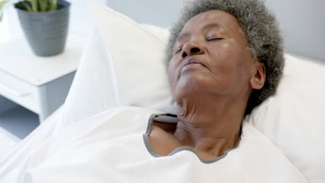 African-american-senior-female-patient-sleeping-in-bed-in-hospital-room,-slow-motion