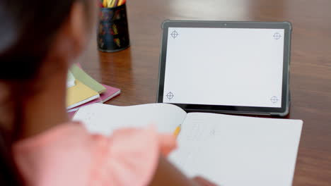 Biracial-girl-having-elementary-school-class-on-tablet-with-copy-space-on-screen,-slow-motion