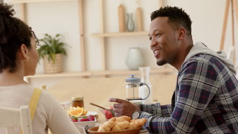 Glückliches-Afroamerikanisches-Paar,-Das-Zu-Hause-Spricht-Und-Frühstückt,-Zeitlupe