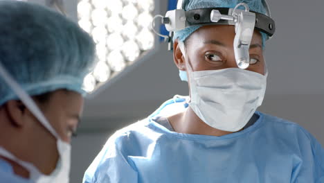 African-american-female-surgeons-operating-on-patient-in-operating-theatre,-slow-motion