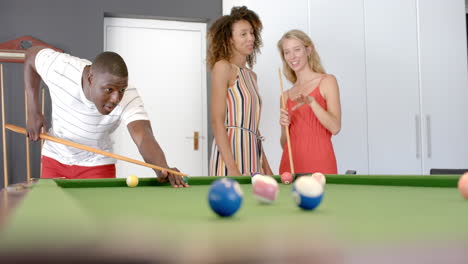Young-African-American-man-plays-pool-with-biracial-and-Caucasian-women