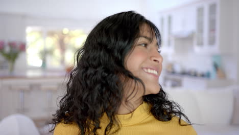 Portrait-of-happy-biracial-female-teenager-with-long-hair-at-home,-slow-motion