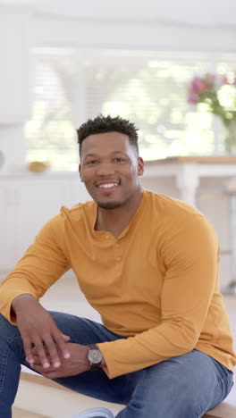 Vertical-video-of-portrait-of-happy-african-american-man-at-home,-slow-motion