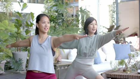 Glückliche-Asiatische-Freundinnen-Praktizieren-Yoga-Auf-Der-Sonnigen-Terrasse,-Zeitlupe