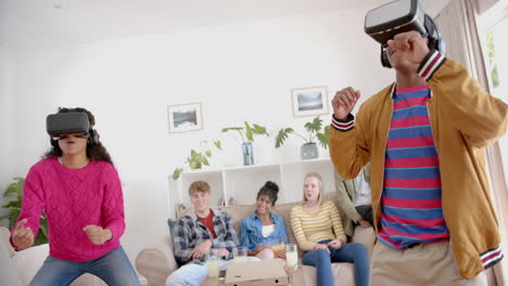 Happy-diverse-group-of-teenage-friends-with-pizza-playing-with-vr-headsets-at-home,-slow-motion