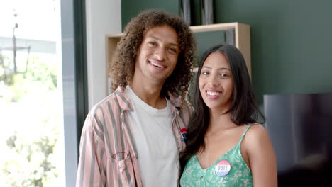 Biracial-couple-at-home-wearing-'I-Voted'-stickers,-highlighting-their-civic-engagement,-slow-motion