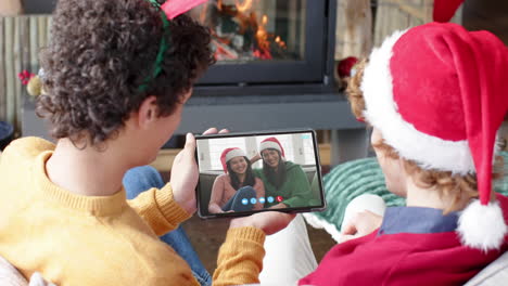 Caucasian-male-friends,-mother-and-daughter-having-christmas-tablet-video-call,-slow-motion
